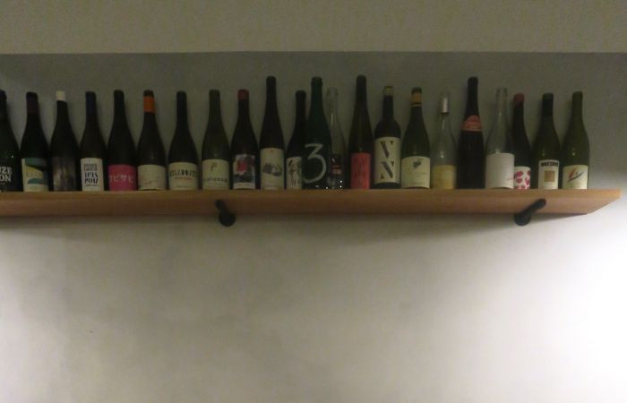 Auf einem Regal aneinandergereihte Weinflaschen im Restaurant Barra in Berlin